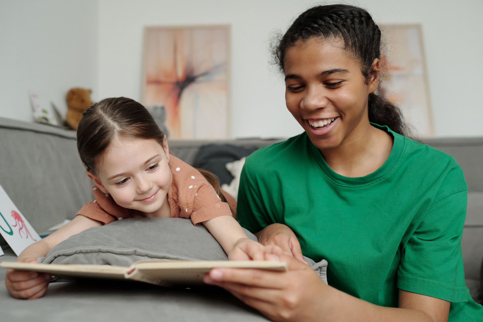 Sitter reading book to cute little girl