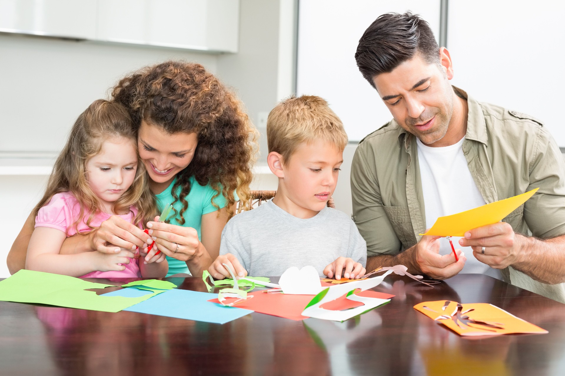 Happy family doing arts and crafts together at the table